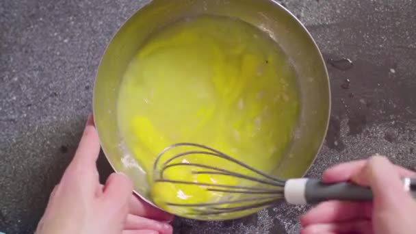 Hands of a confectioner mixing eggs with lemon juice — Stock Video