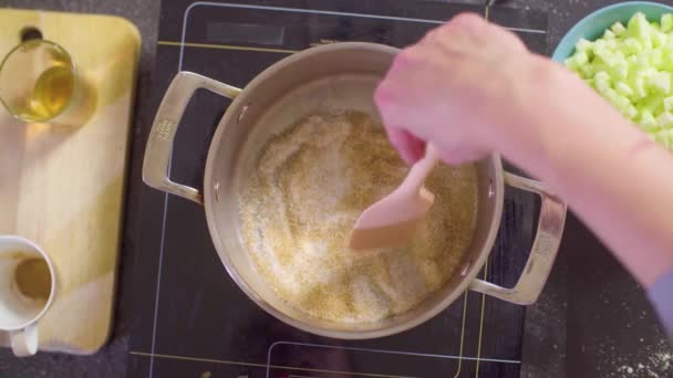 Händerna på en konditor smältande socker på botten av pannan — Stockvideo