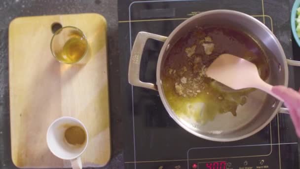 Hände eines Konditors, der Zucker am Boden der Pfanne schmelzen lässt — Stockvideo