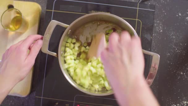 Manos de un confitero mezclando manzanas y azúcar derretida — Vídeos de Stock