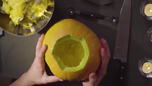 Las manos femeninas tallan de una calabaza Jack-o-linterna para la celebración de Halloween — Vídeos de Stock