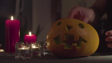 Bir el bir mum bir Jack-o-lantern yerleştirir..