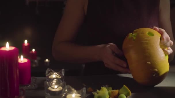 Mãos femininas entalham de uma abóbora Jack-o-lanterna da celebração de Halloween — Vídeo de Stock
