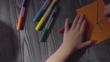 Kızlar el örümcek ağı üzerinde bir kart çizim. Cadılar Bayramı kutlama için hazırlanıyor