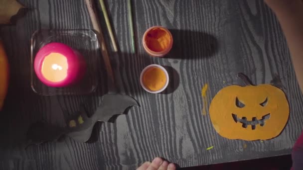 The girl painting the spider. Preparing for the celebration of Halloween — Stock Video