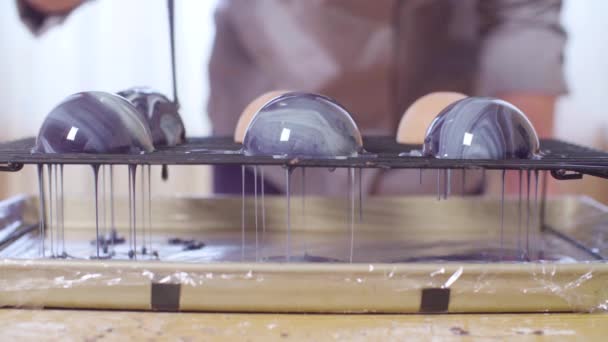 糕点厨师的手在冷冻慕斯的球上倒温热的镜子釉 — 图库视频影像