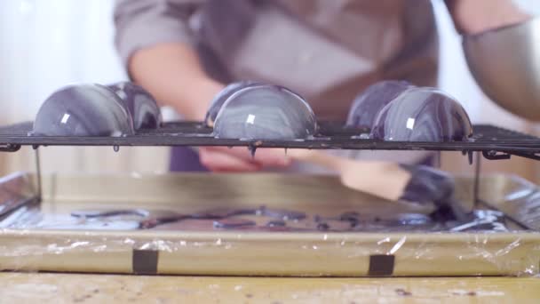 Handen van de gebak chef-kok stromende warme mirror glaze op de ballen van bevroren mousse — Stockvideo