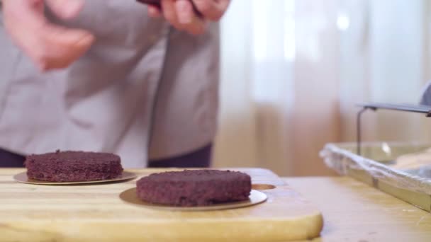 Mani dello chef pasticcere mettendo torta rotonda sul supporto torta — Video Stock