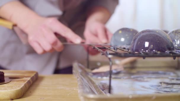 Manos del chef de pastelería poniendo bolas esmaltadas en los pasteles — Vídeo de stock