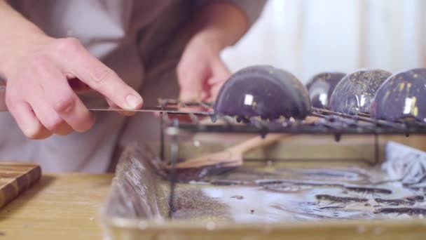 Manos del chef de pastelería poniendo bolas esmaltadas en los pasteles — Vídeo de stock