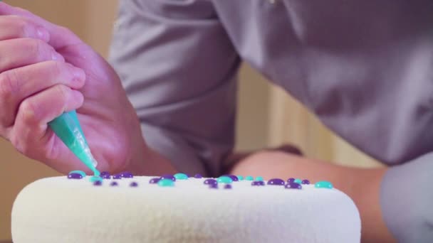 Hands decorating the cake with silver droplets — Stock Video
