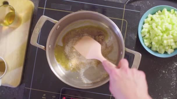 Mains d'un confiseur fondant du sucre au fond de la casserole — Video