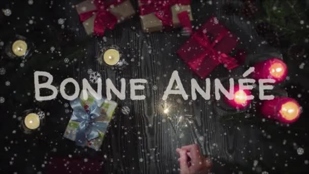 Animação Bonne Annee - Feliz Ano Novo em língua francesa, mão feminina segurando um sparkler — Vídeo de Stock