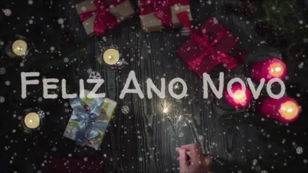 Animation Feliz Ano Novo - Happy New Year in portuguese language, female hand holding a sparkler — Stock Video