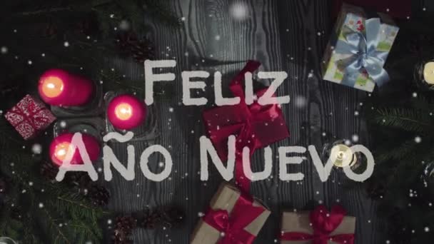 动画费利兹·阿诺·新欧-新年快乐在西班牙语, 白色字母, 红色蜡烛和礼物 — 图库视频影像