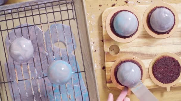 Hands of the pastry chef putting glazed balls on the cakes — Stock Video