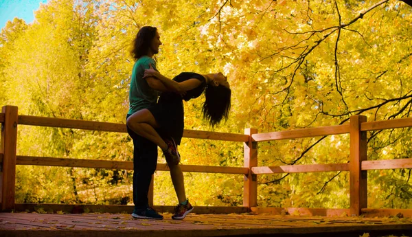 Silhouettes de jeunes couples heureux dansant sur le pont — Photo