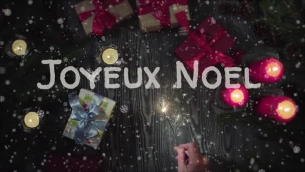 Animación Joyeux Noel - Feliz Navidad en francés, mano femenina sosteniendo un bengala — Vídeo de stock