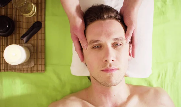 Mains de thérapeute faisant massage du visage masculin — Photo
