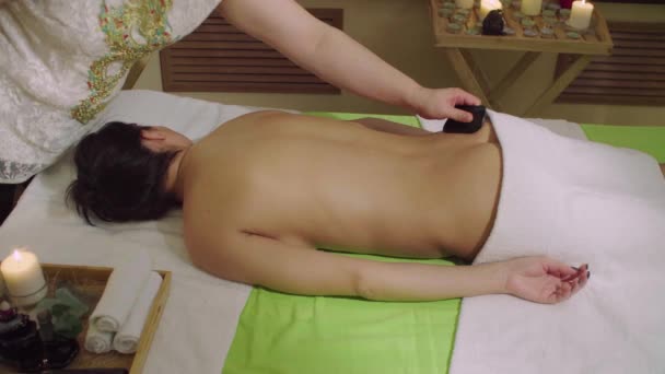 Médico chinês fazendo massagem de pedra para uma jovem mulher — Vídeo de Stock