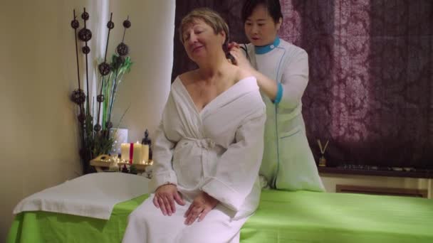 Jonge chinese arts doen massage met een senior vrouw — Stockvideo