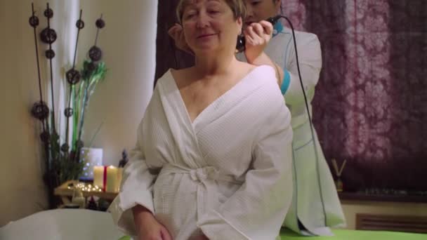 Joven médico chino haciendo masaje a una mujer mayor — Vídeo de stock