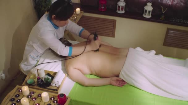 Junge chinesische Arzt tut Massage zu einer älteren Frau — Stockvideo