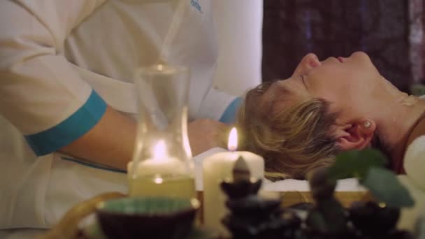 Unga kinesiska läkare gör kosmetiska massage till en äldre kvinna — Stockvideo