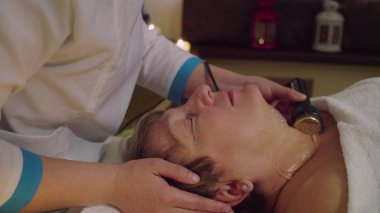 Genç Çinli doktor için üst düzey bir kadın kozmetik masaj yapıyor