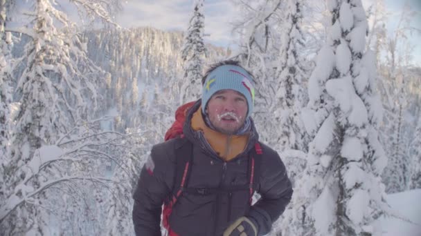 Karlı bir ormanda genç kayakçı portresi. — Stok video
