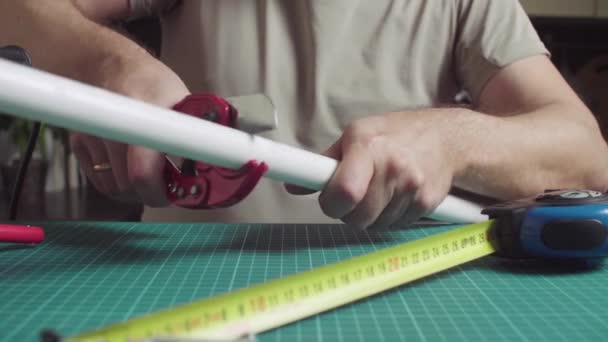 Mains mâles mesurant et coupant des tuyaux en polypropylène — Video