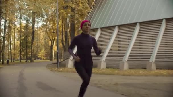 Jonge Sportvrouw loopt langs de weg — Stockvideo