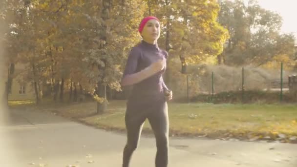 Молода спортсменка біжить по дорозі — стокове відео