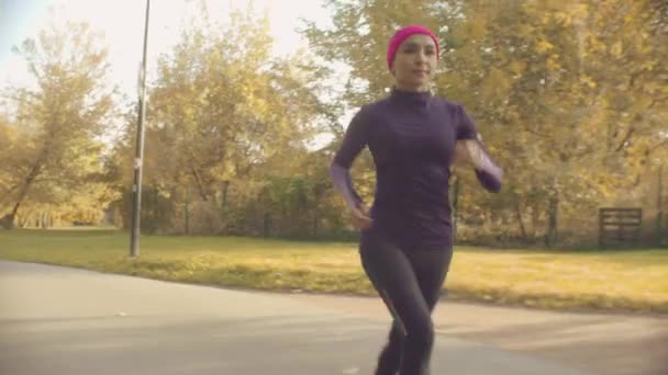Young sportswoman running along the road — Stock Video
