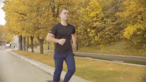 Energikus férfi sportruházat fut végig a parkban road — Stock videók