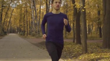 Yolda bir parkta koşan genç adam
