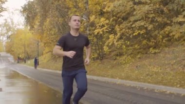 Adam parkta yol boyunca çalışan spor giyim