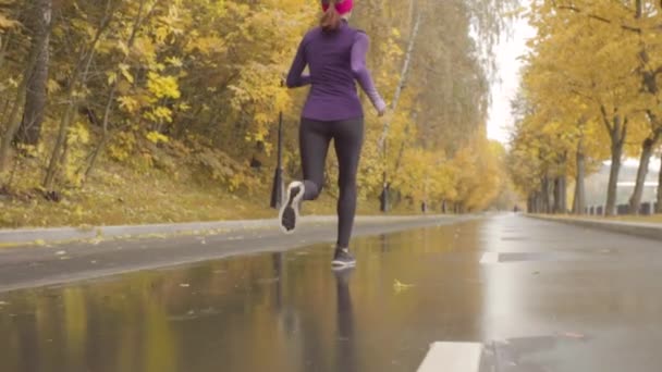 Jonge Sportvrouw loopt langs de weg — Stockvideo