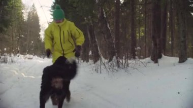 Kış ormandaki köpekle oynayan kadın