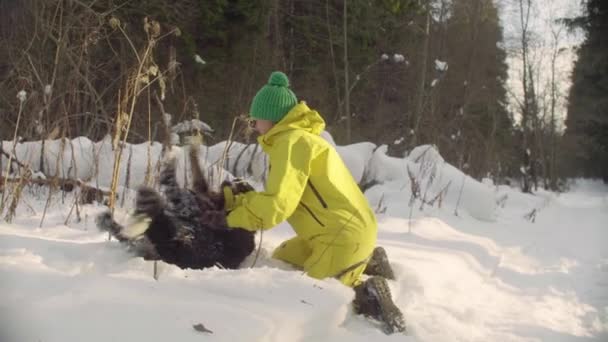 Mujer baña perro peludo en la nieve — Vídeos de Stock