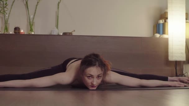 Young woman doing yoga asana in bright studio — 비디오