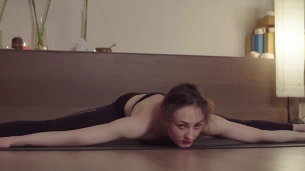 Giovane donna che fa yoga asana in studio luminoso — Video Stock