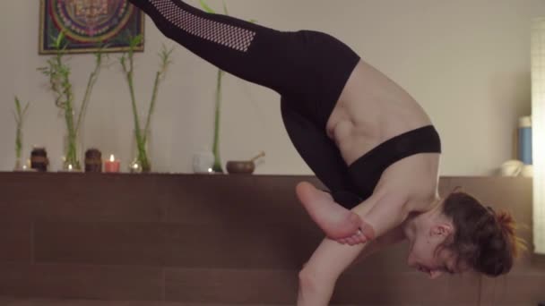 Jeune femme faisant des asanas de yoga dans un beau studio — Video