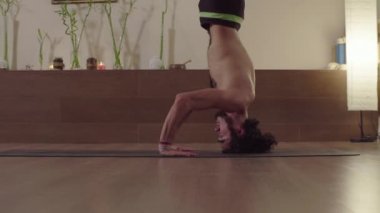 Yoga yapan genç adam asana - baş dik denge