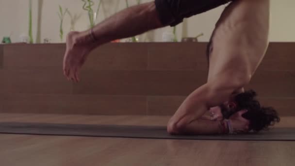 El hombre comienza a hacer pose de yoga difícil - equilibrio de la cabeza de pie — Vídeos de Stock