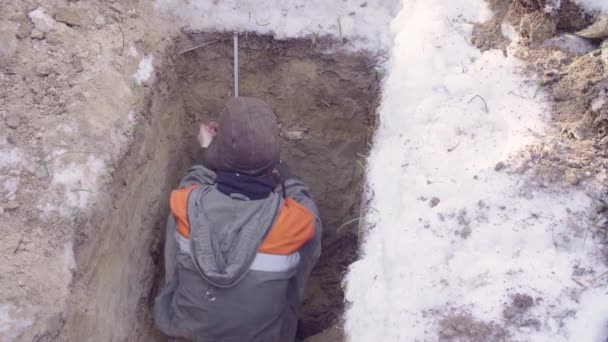 Ecoloog zittend in de bodem spleet — Stockvideo