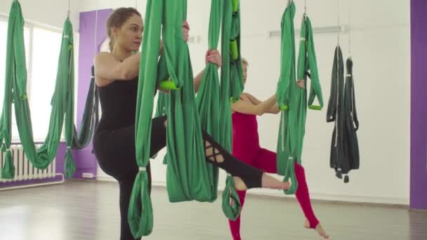 Zwei Frauen machen synchron Yoga-Übungen in der Hängematte — Stockvideo