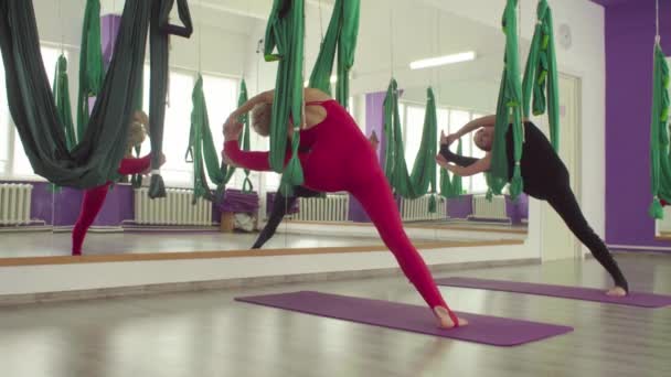 İki kadın eşzamanlı hamak yoga egzersizleri yapıyor — Stok video