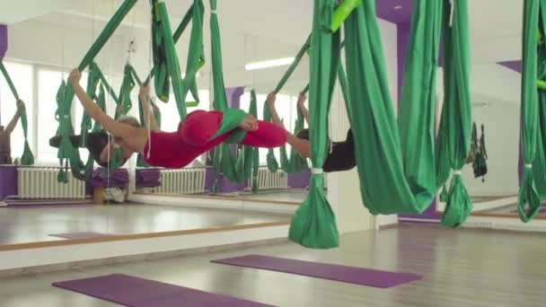 Antenn yoga. Två kvinnor hängande i hängmattor upp och ner — Stockvideo