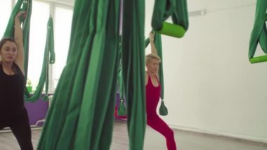 Hamak tutan yoga egzersizleri yapan iki kadın